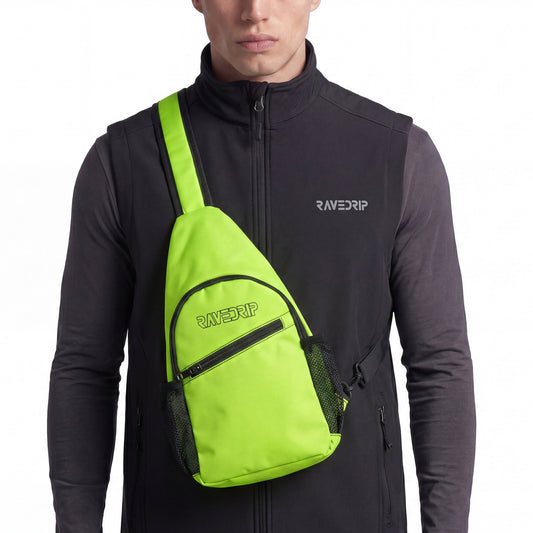 Close-up cropped studio shot of a RAVEDRIP neon green canvas sling chest bag with its distinct vertical teardrop shape and black zipper. The bag features the RAVEDRIP black logo, worn front-facing over a black tactical utility vest and dark grey long-sleeve shirt. Premium e-commerce techwear product photography.
