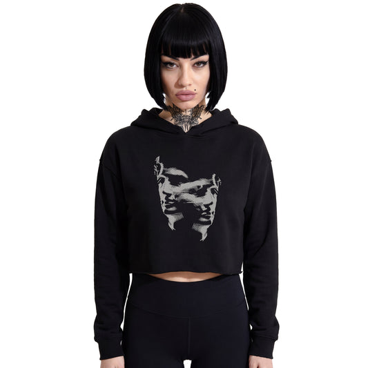 Front-facing studio product shot of a female model with a black bob haircut wearing a RAVEDRIP black cropped hoodie. The hoodie features dropped shoulders, a raw edge hem, and a grey abstract dual-face glitch graphic printed on the chest. She is paired with tight-fitting high-waisted black leggings against a solid white background. Premium e-commerce streetwear fashion look.