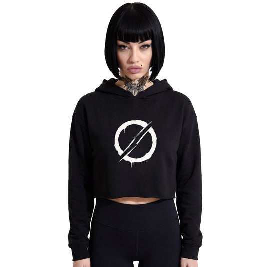 Front-facing studio product shot of a female model with a black bob haircut wearing a RAVEDRIP black cropped hoodie with hidden drawstrings. Features a bold white grunge stencil circle and slash graphic on the chest. Paired with tight high-waisted black leggings against a solid white background. Underground rave streetwear style.