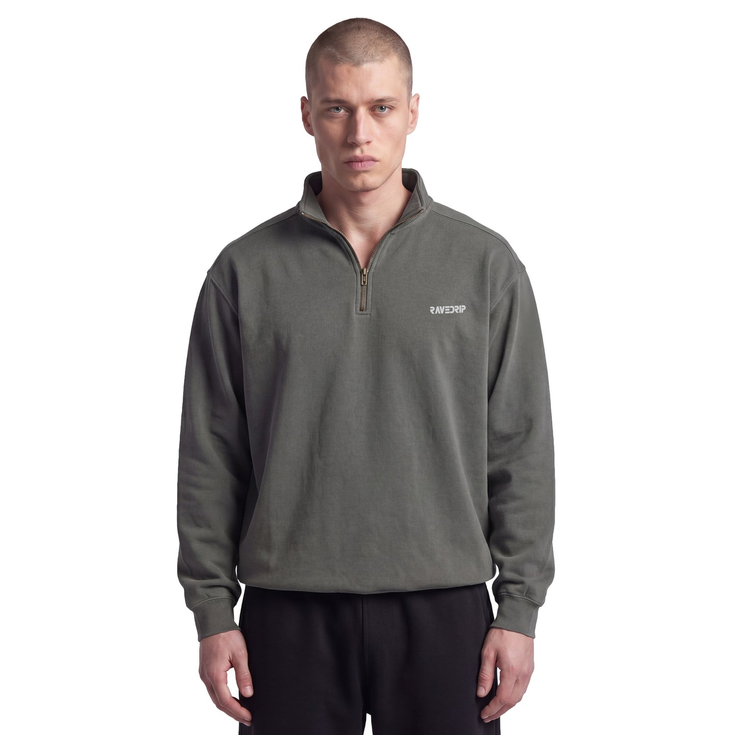 Male model with an edgy aesthetic styling the RAVEDRIP Sector 210 heavyweight quarter-zip sweatshirt in pepper charcoal with black sweatpants on a white studio background.