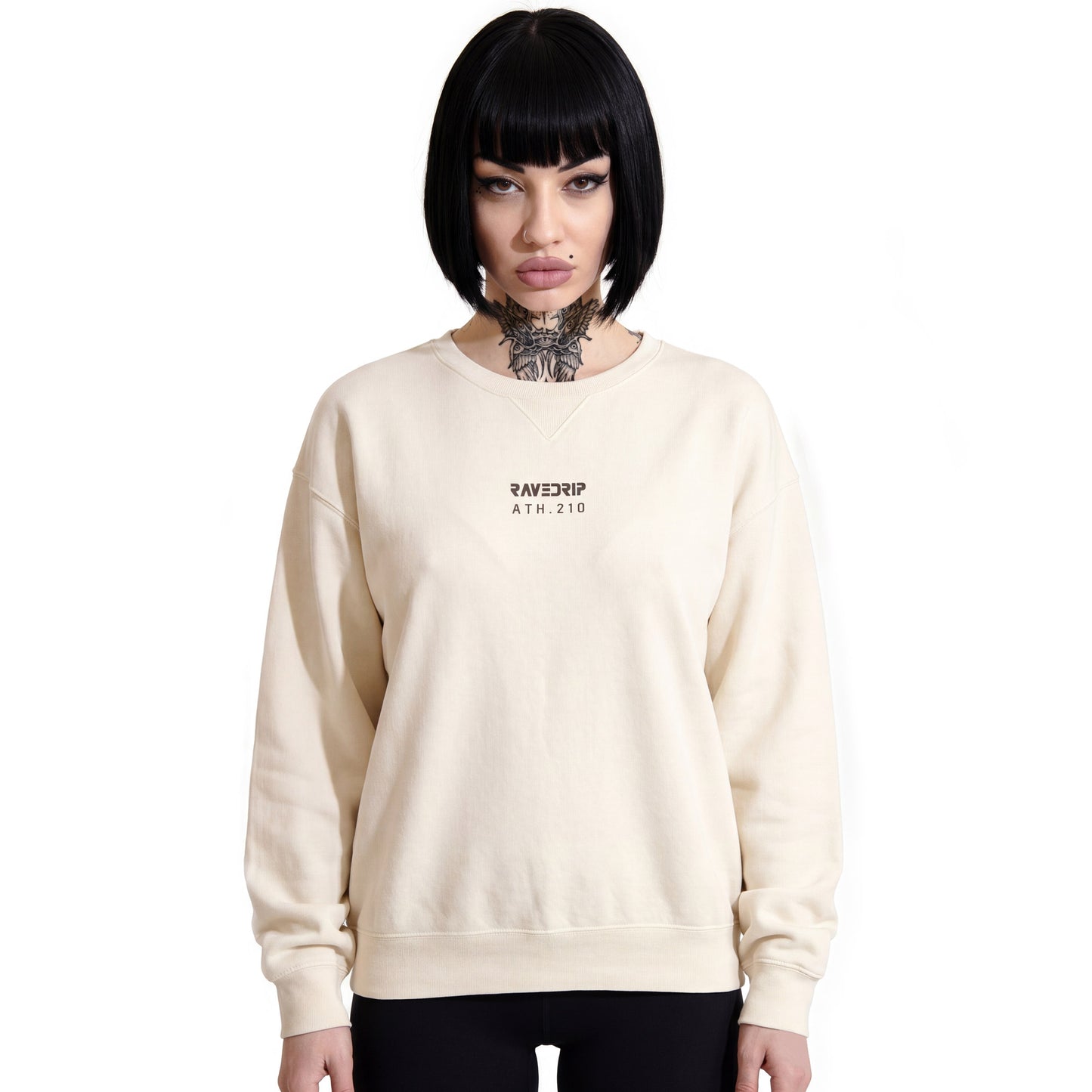 Model with alternative aesthetic styling the RAVEDRIP Sector 210 cream vintage wash crewneck sweatshirt with a centered industrial logo on a white studio background.