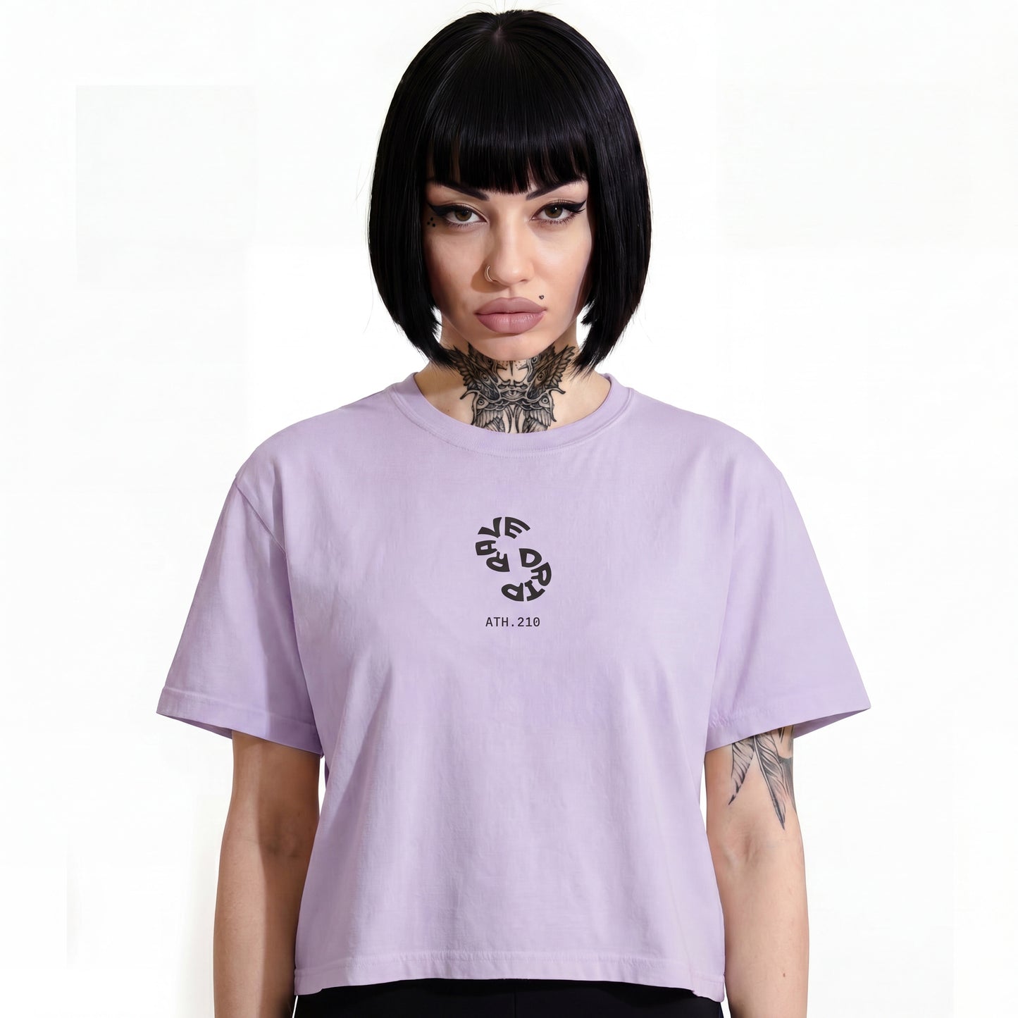 RAVEDRIP Sector 210 Vortex boxy t-shirt in solid Orchid pink, relaxed fit women's streetwear tee with circular warped black typography logo and ATH.210 branding, worn by alternative female model featuring her signature black bob haircut and detailed Seraphim neck tattoo, high-key e-commerce studio photography on pure white background.