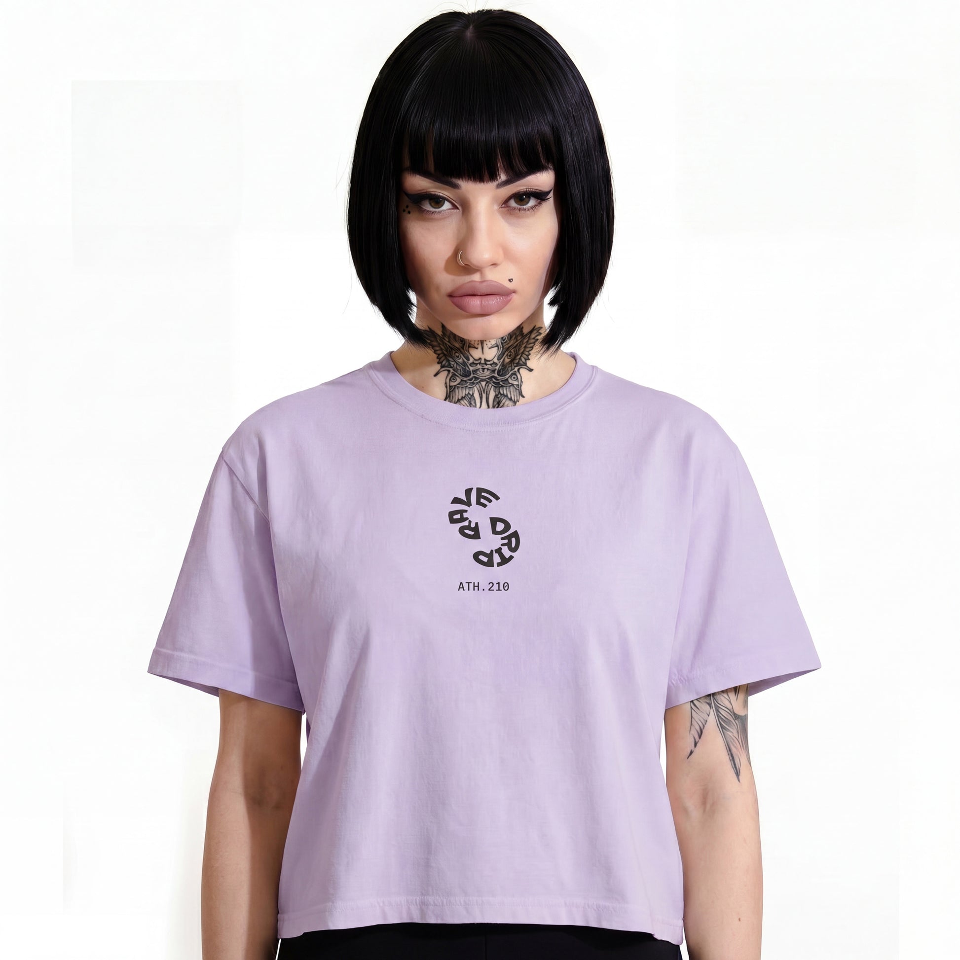 RAVEDRIP Sector 210 Vortex boxy t-shirt in solid Orchid pink, relaxed fit women's streetwear tee with circular warped black typography logo and ATH.210 branding, worn by alternative female model featuring her signature black bob haircut and detailed Seraphim neck tattoo, high-key e-commerce studio photography on pure white background.
