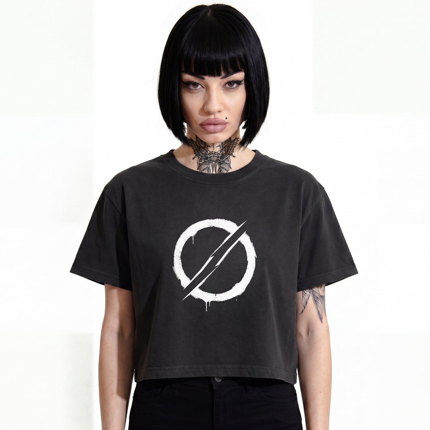 RAVEDRIP The Deviant heavyweight boxy cropped tee in faded black, wide square fit women's streetwear t-shirt featuring a white distressed circular slash symbol graphic print on the chest, worn by alternative female model.