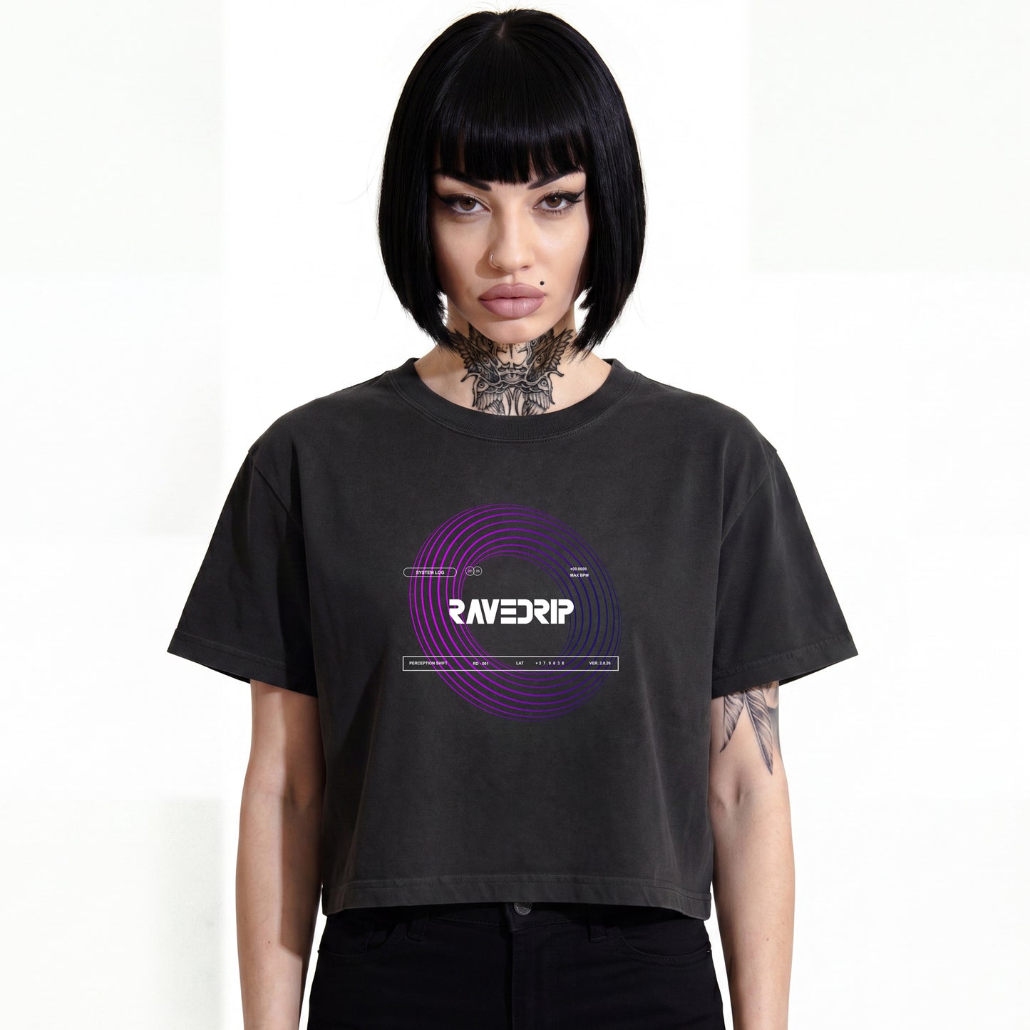 RAVEDRIP Vortex heavyweight boxy cropped tee in faded black, premium wide square fit women's streetwear t-shirt with short mid-bicep sleeves and purple circular vortex graphic print, worn by alternative female model with black bob haircut and neck tattoo, e-commerce studio catalog photography on white background.
