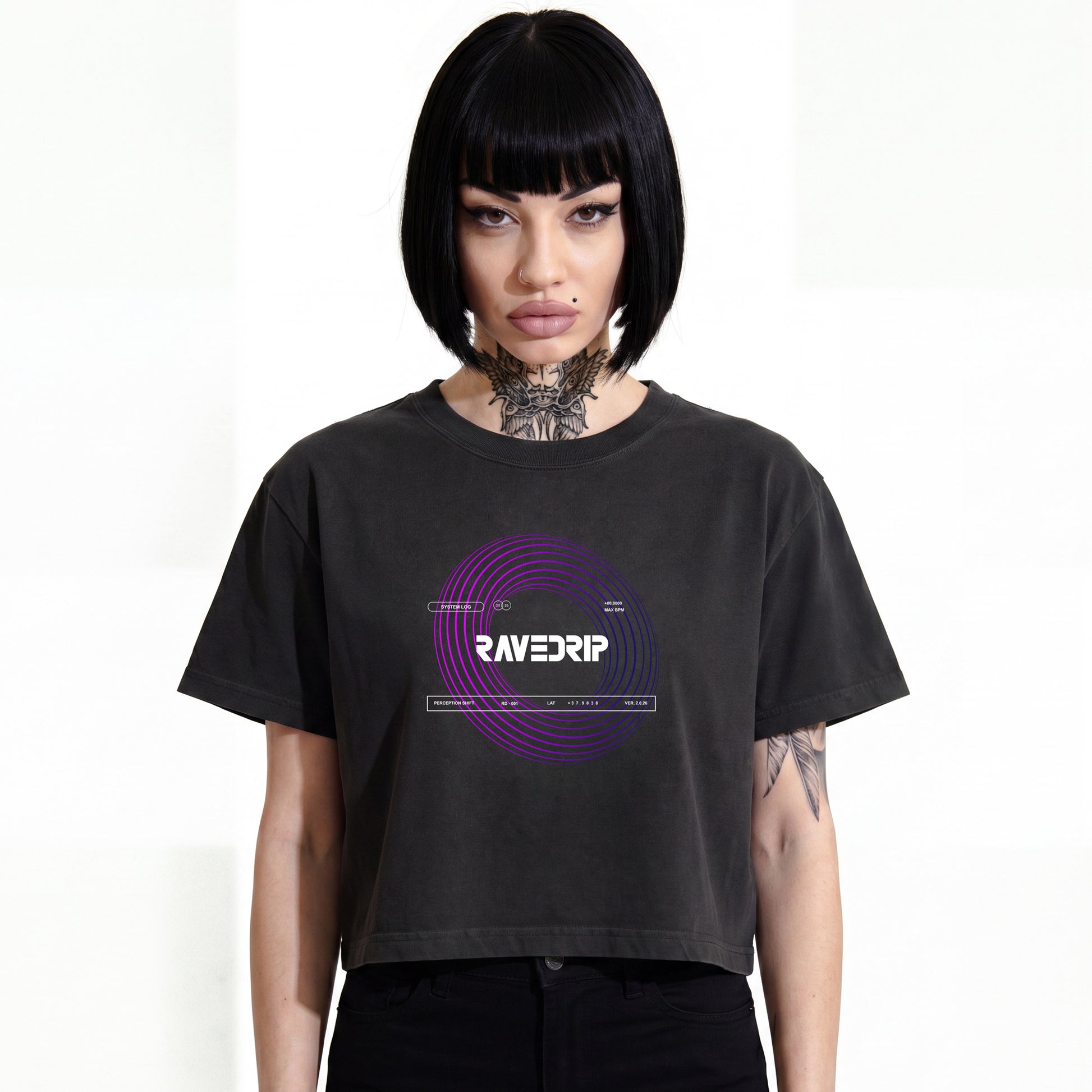 RAVEDRIP Vortex heavyweight boxy cropped tee in faded black, premium wide square fit women's streetwear t-shirt with short mid-bicep sleeves and purple circular vortex graphic print, worn by alternative female model with black bob haircut and neck tattoo, e-commerce studio catalog photography on white background.