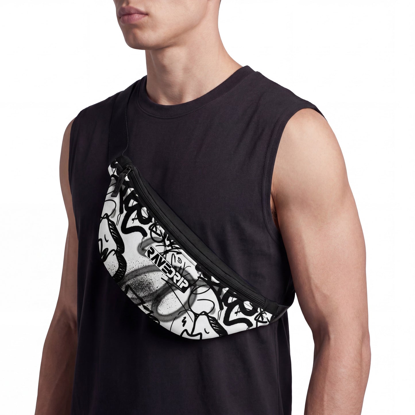 Side angle studio view of a male model wearing a plain black sleeveless cotton t-shirt carrying a RAVEDRIP white and black allover graffiti-print fanny pack crossbody over his chest. The streetwear belt bag showcases bold spray-paint tags, street-art cartoon graphics, and the RAVEDRIP box logo. Premium e-commerce product photography.